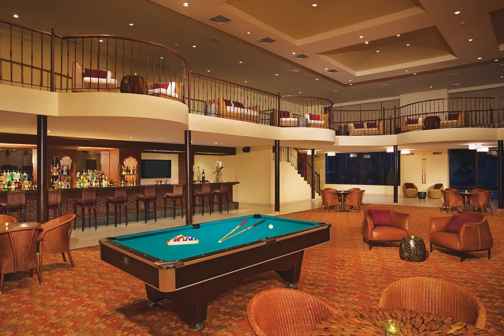 Desires music lounge at Dreams Playa Bonita Panama featuring a stylish bar, billiards table, lounge seating, and an upscale nighttime atmosphere.